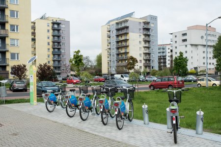 Stacja z miejskimi rowerami na osiedlu mieszkaniowym z wielorodzinnymi blokami