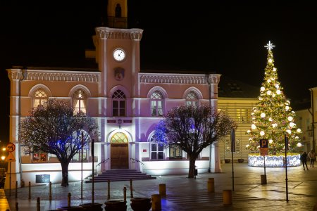 Ratusz po zmroku. Na placyku od strony Urzędu Stanu Cywilnego Stoi duża świąteczna choinka