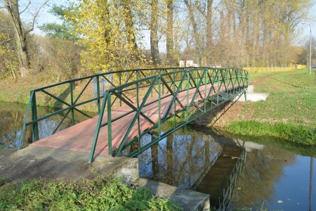 Kładka nad rzeką. Mogą z niej korzystać piesi i rowerzyści. Na metalowej konstrukcji opartej na betonowych blokach ułożono drewniane podłoże. Balustrady z metalowych krzyżujących się długich, wąskich elementów