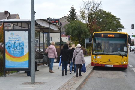 Na przystanek komunikacji miejskiej wjeżdża autobus, do którego podchodzą pasażerowie