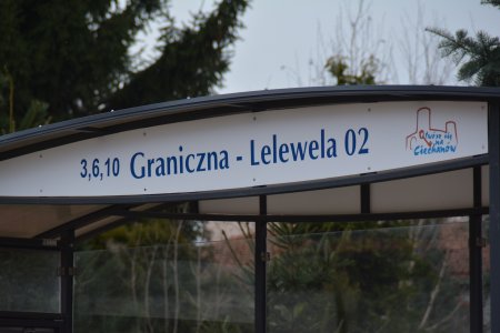 Owalna tablica z nazwą przystanku, zamontowana pod zadaszeniem przystanku autobusowego. Napis brzmi: 3,6,10 Graniczna – Lelewela 02. Obok napisu po prawej znajduje się logo miasta