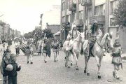 Dawne zdjęcie - ul. Warszawska, rok 1965., uroczysty pochód z okazji 900-lecia Ciechanowa. Na pierwszym planie mężczyzna i kobieta jadą konno w strojach stylizowanych na średniowieczne