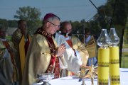 Zbliżenie na ołtarz i biskupa Piotra Liberę odprawiającego mszę św.. Na drugim planie kilku duchownych uczestniczących w odprawianiu mszy św.