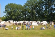 Zajęcie z oddalenia, namioty historyczne ulokowane na błoniach, uczestnicy obchodów odwiedzający dawne stanowiska rzemieślnicze