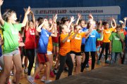 Ćwiczenia w grupie. Dzieci w kolorowych koszulkach Athletics Camp