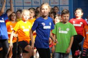 Dzieci w barwnych koszulkach Athletics Camp uczą się Zumby