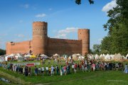 Na błoniach po południowej i zachodniej stronie stoi wiele namiotów. Dużo ludzi uczestniczy w imprezie średniowiecznej