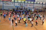 Zdjęcie wykonane z góry. W kadrze ćwiczące uczestniczki Maratonu Zumba Fitness. Na drugim planie na scenie instruktorzy demonstrujący prawidłowe wykonywanie ćwiczeń