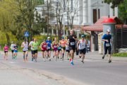 Grupa biegaczy na trasie. W tle opinogórski kościół