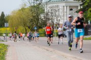 Grupa biegaczy na trasie. W tle opinogórski kościół