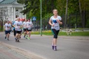 Grupa biegaczy na trasie. Na pierwszym planie biegnąca rzeczniczka prezydenta Ciechanowa Renata Jeziółkowska. W tle opinogórski kościół