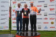 Trzech mężczyzn na najwyższym stopniu podium z medalami na piersiach