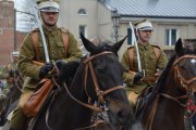 Zbliżenie na dwóch wojskowych w dawnych mundurach jadących konno