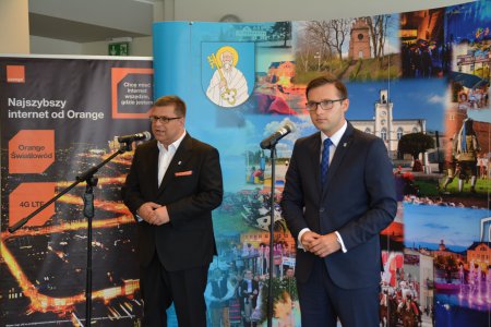 Podczas konferencji prasowej przy mikrofonach stoją: Jacek Kowalski z Orange Polska oraz Krzysztof Kosński, prezydent miasta