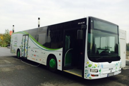 Biało-zielony autobus, w którym można dowiedzieć się jak przeciwdziałać zmianom klimatu oszczędzając energię