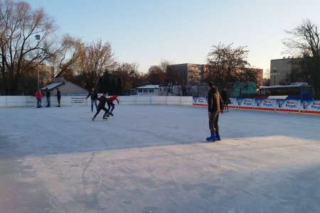 Lodowisko przed Halą Sportową. Na tafli ślizga się kilka osób