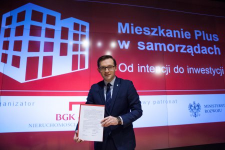 Prezydent Ciechanowa Krzysztof Kosiński na tle ścianki promującej program Mieszkanie Plus w samorządach.