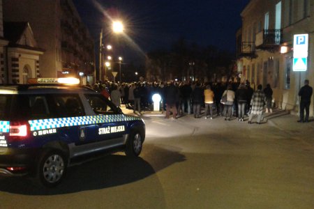 Grupa uczestników Drogi Krzyżowej wchodzi na pl. Kościuszki. Z tyłu widać samochód Straży Miejskiej