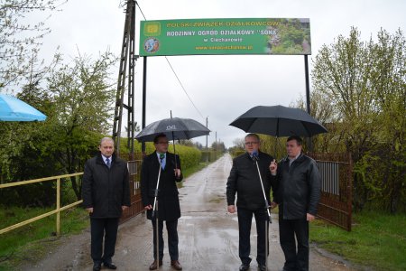 Trwa konferencja prasowa. Przy bramie ogródków działkowych o inwestycji mówią przedstawiciele zakładu wodociągów i urzędu miasta. Pada deszcz