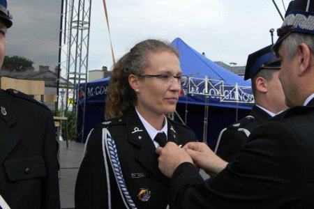 Prezes Zarządu Głównego OSP RP Waldemar Pawlak przypina odznaczenie do munduru miejskiej strażniczki Anny Wodzyńskiej