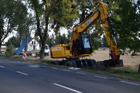 Na poboczu drogi stoi koparka