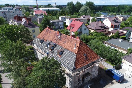 Zdjęcie z wysoka na remontowany dach. Zdjęto już część starej dachówki