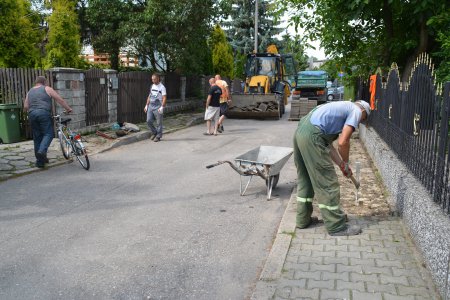 Robotnicy układają nową nawierzchnię chodnika z brukowej kostki