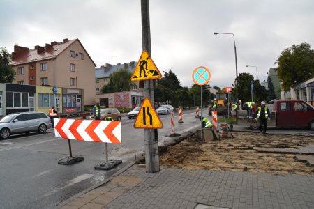 Z fragmentu chodnika/podjazdu zdjęto kostkę. Na jezdni ustawiono barierkę ochronną. Na słupie lampy ulicznej powieszono znaki informujące o robotach drogowych. W miejscu remontu pracują ludzie w odblaskowych kamizelkach