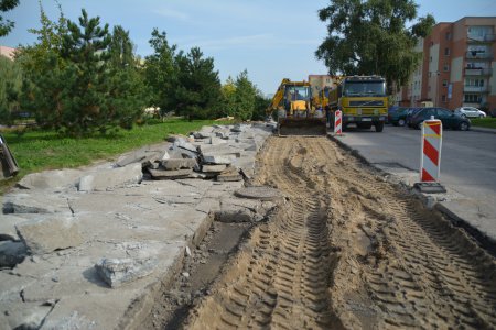 Koparka usuwa starą, popękaną nawierzchnię parkingu. Wzdłuż jezdni zerwane zostały stare płyty i wierzchnią warstwę gruntu