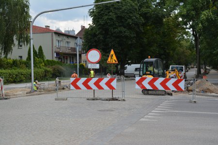 Ulica Sienkiewicza - widok od strony dworca PKP w stronę wiaduktu. Barierki zabezpieczają przed wjazdem na teren budowy. W głębi widać maszyny, które będą używane do remontu drogi