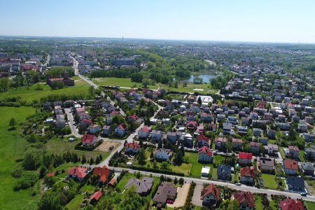 Miasto z lotu ptaka. Na zdjęciu część Ciechanowa z domami jednorodzinnymi, zwana Podzamczem. Po lewej stronie zdjęcia widoczne są błonia i Zamek Książąt Mazowieckich.