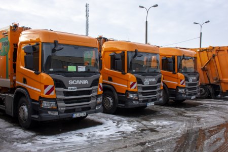 Trzy nowe, pomarańczowe pojazdy marki SCANIA, przeznaczone do zbiórki odpadów.