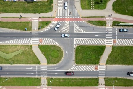 Widziane z wysoka skrzyżowanie ulicy Armii Krajowej z ulicą Harcerską. Ulica Armii Krajowej ma dwa pasy ruchu oddzielone od siebie szerokim pasem zieleni. Biegnie tędy także ścieżka rowerowa. W obrębie skrzyżowania są trzy przejścia dla pieszych.