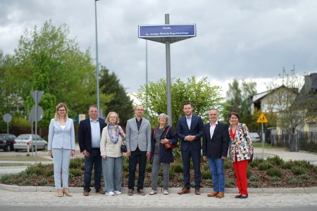 Na tle nowo nazwanego ronda stoi rząd osób, między innymi Krzysztof Leszczyński - przewodniczący ciechanowskiej Rady Miasta, Krzysztof Kosiński - prezydent Ciechanowa, Iwona Kowalczuk - zastępca prezydenta Ciechanowa oraz Marzena Lentowszczyk - kierownik Parku Nauki Torus. Na rondzie rosną niskie byliny. Pomiędzy roślinami wysypana jest kora. Na środku ronda, na wysokim słupie, pomalowanym na szaro znajduje się nazwa ronda. Nazwę umieszczono na trzech niebieskich wąskich tablicach tak, by była widoczna z każdego z trzech kierunków wjazdu na skrzyżowanie. W tle rosną drzewa. W głębi po prawej są jednorodzinne domy.