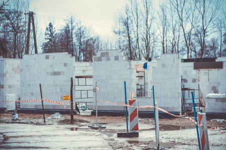 Budowa zaplecza weterynaryjnego i socjalnego. Powstają jasne mury nowego obiektu. Wewnątrz stoją rusztowania. Plac budowy jest otoczony biało-czerwoną taśmą, zamocowaną na słupkach.