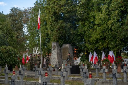 Kwatera Wojska Polskiego i Ofiar Terroru na cmentarzu komunalnym. Na pierwszym planie kilka rzędów niskich betonowych krzyży, stojących dość ciasno jeden obok drugiego. W głębi postument z pamiątkową tablicą. Przed postumentem maszt z polską flagą. Po bokach postumentu ustawiono stojaki z biało-czerwonymi flagami. W tle rosną wysokie, zielone drzewa i krzewy.