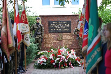 Tablica poświęcona żołnierzom Powstania Warszawskiego. Na tablicy znajduje się napis: Ciechanowianom walczącym i poległym w Powstaniu Warszawskim w 50. rocznicę społeczeństwo Ciechanowa; sierpień 1994 r. Pod tablicą, na granitowym postumencie znajduje się znak Polski Walczącej. Po obu stronach znaku umieszczono nazwiska poległych powstańcow. Pod postumentem ułożono wieńce z biało czerwonymi wstęgami. Po obu stronach postumentu stoi warta honorowa oraz dwa rzędy sztandarow.