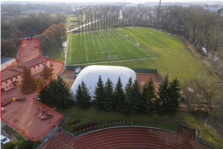 Zdjęcie stadionowego kompleksu sportowego wykonane z wysoka. Po lewej na czerwono zaznaczono parking, ktory zostanie zmodernizowany.